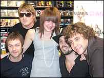 Kasabian posing for a photo with a fan