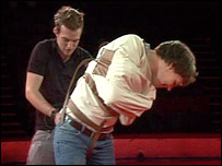 Jonny straps Will into a straight-jacket