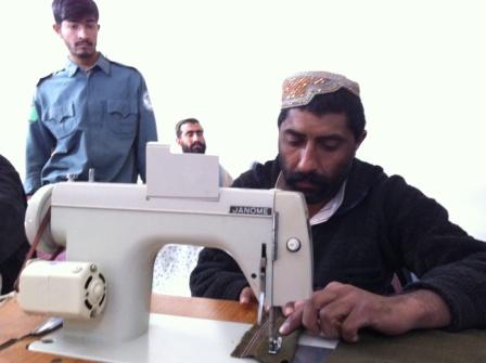 A prisoner in Helmand working on a sewing machine