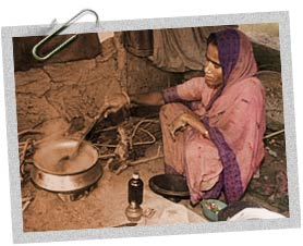 Woman preparing a meal over open fire, India