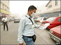 Homem usa máscara para proteger vias respiratórias do nevoeiro
