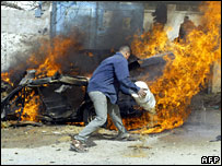 ایک فلسطینی شہری اسرائیل کے فضائی حملے کے نتیجے میں لگنے والی آگ بجھا رہا ہے