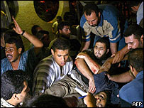 घायल को ले जाते लोग