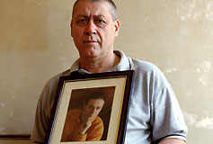 Bob, holding a picture of his son, Darren, who committed suicide.