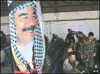 Palestinos carregam cartaz com a imagem de Saddam Hussein