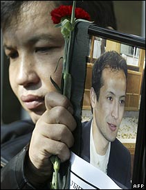 Protestor holds a picture of Alisher Saipov outside Kyrgyzstan's Interior Ministry