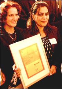 از راست به چپ، فريده سمندر در حال نمايش ايوارد رسانه های آزاد افغانستان