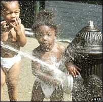 Criança brinca com água de hidrante nas ruas de Nova York