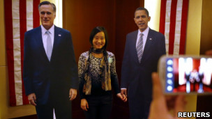 一名中国客人在美国驻北京大使馆主办的大选派对上与奥巴马和罗姆尼的纸板人像合照（7/11/2012）