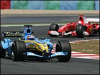 Fernando Alonso seguido de perto pela Ferrari de Schumacher