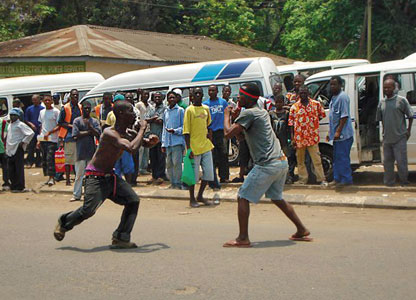 Street vendors ignore traffic and trade blows in the middle of the road to settle a dispute