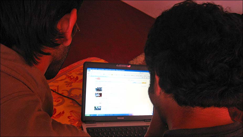 Kashmiris watching YouTube videos in a cybercafe