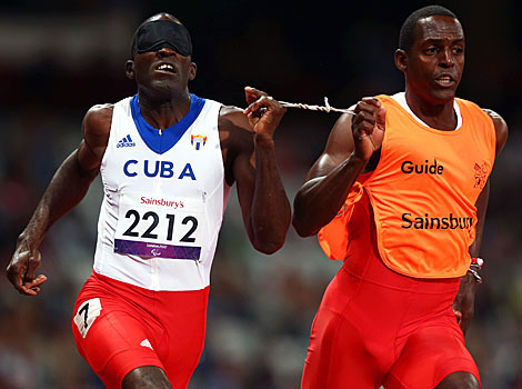 Yaseen Perez Gomez guides Arian Iznaga of Cuba around the track in the men's 200m, T11 race.