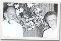 Rheithir Michael Williams a'r Warden Helen Jenkin Jones gyda gosodiadau hardd wrth fynedfa'r Eglwys 