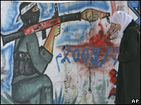 Mulher passa em frente a grafito pró-Hamas em Gaza