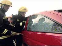 Firefighters cutting people from a car