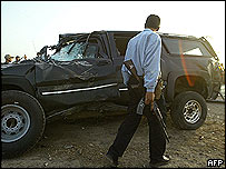 Policial iraquiano observa veículo atacado
