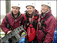 Three people with a crate