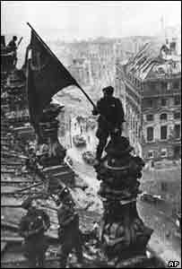 Một người lính Hồng quân vẫy cờ trên nóc tòa nhà Reichstag