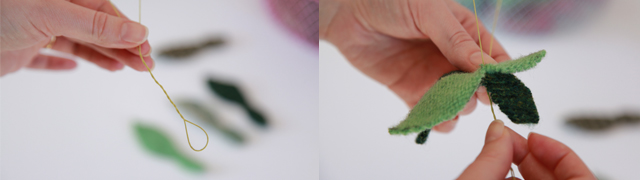 Hands holding leaf shapes made from fabric and thread