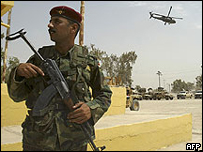 Soldado iraquiano com helicóptero dos EUA ao fundo