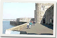 Muriau'r castell ar lan y Fenai