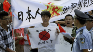 北京反日示威者在日本大使馆外举起呼吁中国民众抵制日货的标语（13/9/2012）