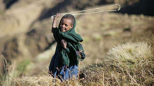 Maza yn defnyddio sling i ddychryn mwncis o'r cynhaeaf © Timothy Allen