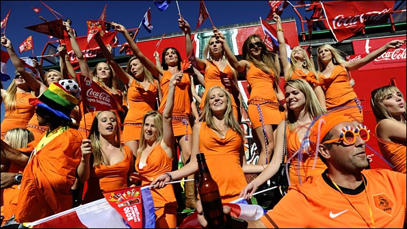 A group of women wearing orange mini-dresses