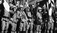 Japanese soldiers raise their rifles in celebration after the fall of Hong Kong