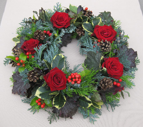 a the fir cones and cut the rose stems short and tuck them firmly between the leaves