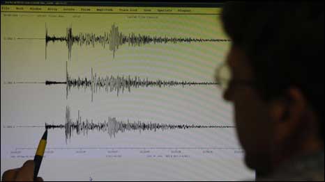 خبير في مركز الأرصاد الجوية في هامبورج بألمانيا يظهر على شاشته الزلزال الذي فجر التسونامي في جزيرة ساموا 