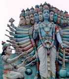 Arjuna, a human man, kneels before Krishna, the avatar of Vishnu, who is showing himself in a many-headed, many-armed form to persuade Arjuna to fight