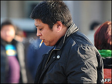 北京街頭一名男子叼著香煙走過（7/1/2011）