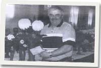 Edwin Jones gyda'i hoff flodau, sef y dahlias