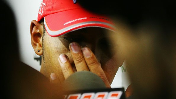 Lewis Hamilton looks downcast as he talks to the media about his retirement from the Singapore Grand Prix