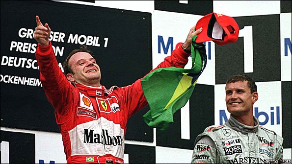 Rubens Barrichello celebrates winning the 2000 German Grand Prix, his maiden Formula 1 victory, watched by McLaren's David Coulthard