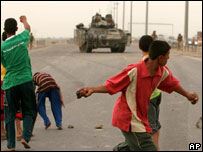 Iraquianos jogam pedras em tanque britânico que sofreu ataque