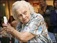 An elderly woman plays the Wii