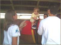 Criança com Down fazendo hipoterapia