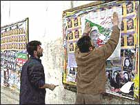 Tahran'da bir duvara yapıştırılan seçim afişleri