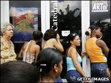 Người dân Cuba đứng trước một cửa hàng có hình ông Fidel