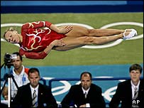 Juízes observam atleta na competição de trampolim