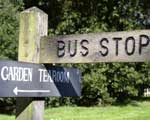 A sign pointing, in one direction, to a bus stop, and in the other direction to a garden tearoom
