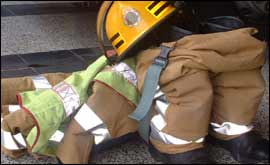 A fireman's uniform lies on the floor 