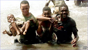 A Mozambican officer carries a baby during an evacuation at Chupanga in Mozambique in 2001