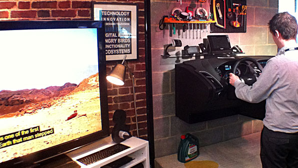 TV in front of brick effect living room wall; and a car dashboard in a garage board