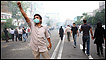 A supporter of Iran's defeated presidential candidate Mir Hossein Mousavi salutes as he prepares to throw stones at riot police during a demonstration on June 20, 2009 in Tehran