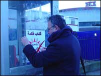 Militante iraquiano prega cartaz de campanha em Londres