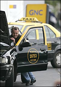 Taxista empurra carro em posto de gasolina argentino